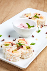 new trend in the Japanese cuisiune. Sweet sushi rolls in pancake with cream cheese, orange and kiwi, peach,