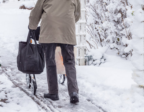 Rentner im Winter mit einem Rollator