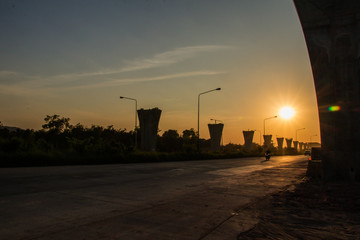 Silhouette of Construction crane and girder of bridge construction site.New expressway construction...