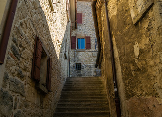 narrow street with old stone fasades and stairs in historical center of san marino city