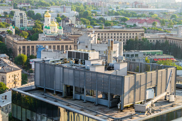 The ventilation and air conditioning systems are located on the roof of a multi-storey building. City landscape.