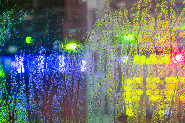 Wet glass of the datacenter. Abstract background. Drops of rain flow down the glass wall of the server room.