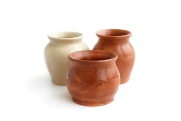 Fototapeta na wymiar Clay pots, made by hand on a potter's wheel from red and white clay. Double burning. Transparent glaze applied by hand - visible potter's fingerprints and brush strokes. Handmade