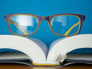 glasses lay on top of opened book