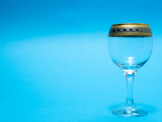 one empty wine glass on blue background