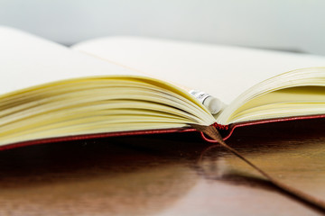 Blank textbook with a dark wood table isolated with a pencil 