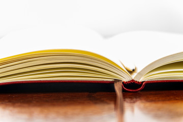 Blank textbook with a dark wood table isolated with a pencil 