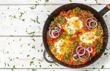 Traditional middle Eastern dish Shakshuka in a pan. The view from the top. Copy-space.
