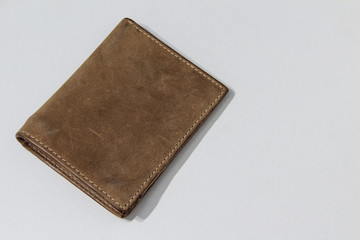 Close-up of a beige shabby leather wallet on a white background