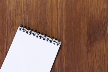 Blank vertical notebook on a background of dark laminated wooden texture