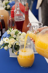 Girl pours juice into a glass jar.