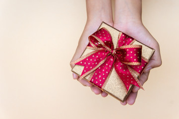gollden gift box with red ribbow , giving gift box for special person on special day