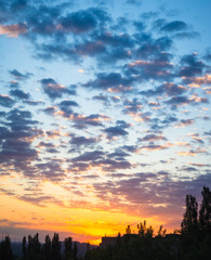 Landscape with dramatic light - beautiful golden sunset with saturated sky and clouds.