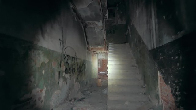 First person view with flashlight in dirty grungy corridors or tunnel in abandoned ruined industrial building, horror escape concept, toned