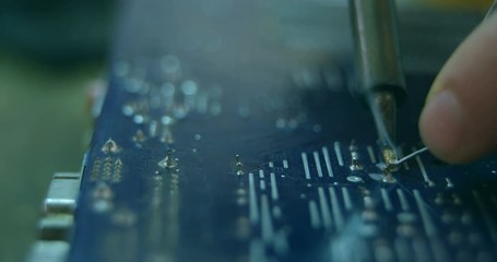 Close-up of robotic engineer assembling circuit board at desk