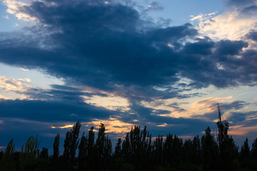 Landscape with dramatic light - beautiful golden sunset with saturated sky and clouds.