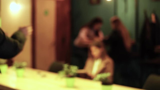 Young pair comes to cafe and polite guy helped cute girl to take off yellow jacket before going to the table