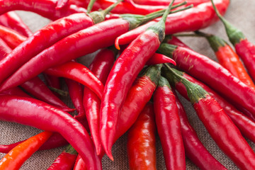 Red chilli pods with green stems on burlap