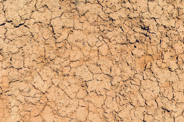 Dry cracked clay with sand, background texture