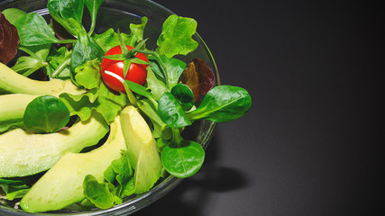 insalata vegetariana con avocado sullo sfondo nero