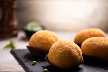 Arancini rice and meat dish on black