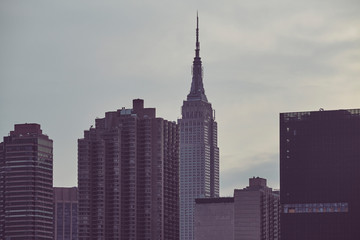 New York City skyscrapers silhouettes at sunset, color toning applied, USA.