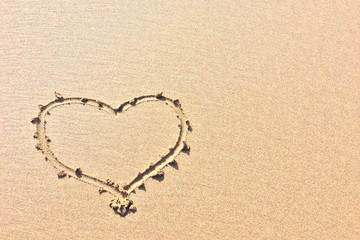 Fototapeta na wymiar finger drawn heart on the sand, symbol of love