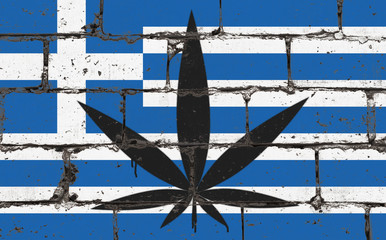 Graffiti street art spray drawing on stencil. Cannabis leaf on brick wall with flag Greece
