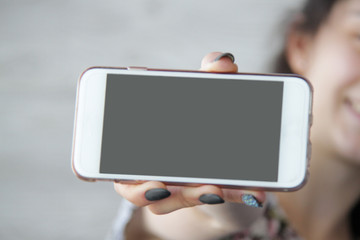 Image a close up of female hands with phone, the girl on a background