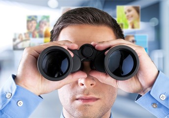 Young handsome man in shirt  with binoculars