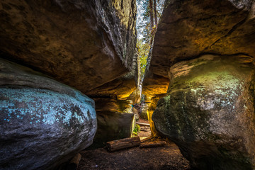 Narrow passage between big rocks in stone labyrinth Bledne skaly, Szczeliniec Wielki in National Park Stolowe Mountains, Poland