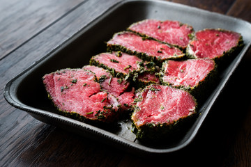 Package of Raw Tenderloin Meat with Herbs and Spices in Plastic Box / Container.