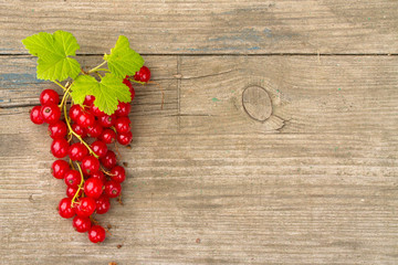 bunch of red currants on old wooden Board