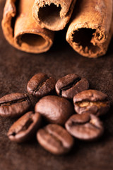 Ziarna kawy i laski cynamonu na brązowym tle