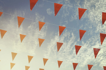 Red Bunting Flags on Cloudy Blue Sky Background with Retro Filter Effect