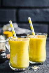 Cinnamon ginger turmeric smoothie on dark background. Selective focus, space for text.