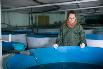 Woman near fish tank on sturgeon farm