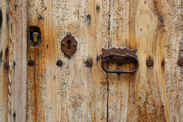 Texture of ancient wooden door with keyholes and handle