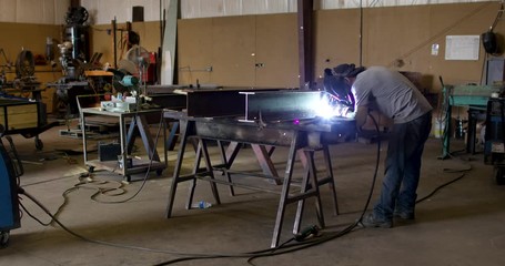Worker Welding In Machine Shop Wide
