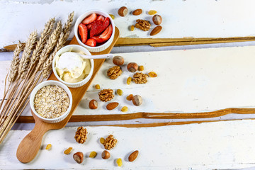 ingredients healthy breakfast - oatmeal, yogurt, strawberries - health and diet concept, wheat spikes on a white wooden background, copy space, top view, set