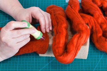 above view of craftsman works with felting punch