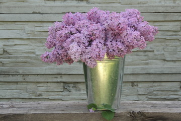 Букет сирени в металлическом ведре в весеннем саду 