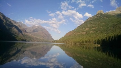 Fototapeta na wymiar Upper Kintla Lake Glacier National Park in Montana. Beautiful reflection in lake flanked by forest of trees and mountain peaks. Utopian paradise away from cities and crowds very peaceful