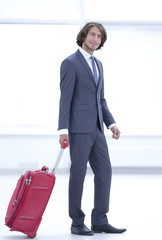 portrait of young businessman with suitcase