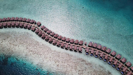 Beautiful winding row of bungalows in water at Maldives