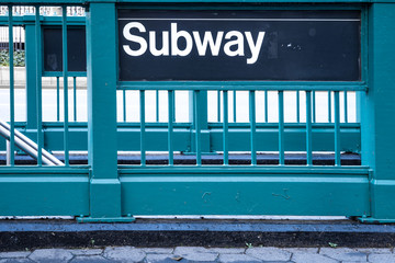 New York style subway sign on green steel fence