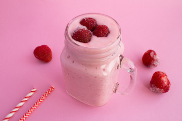 Smoothies with yogurt  and frozen strawberry on the pink background