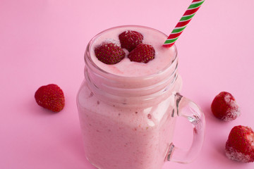 Smoothies with yogurt  and frozen strawberry on the pink background.Closeup.