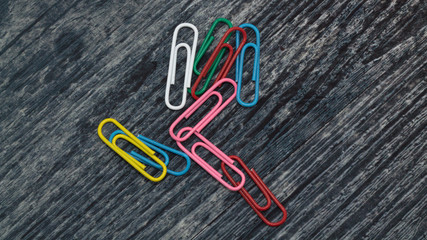 multicolored paper clips on a wooden table, blank for designers 