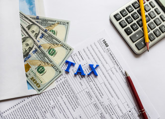 tax form 1040, calculator, pencil and pen on a white background